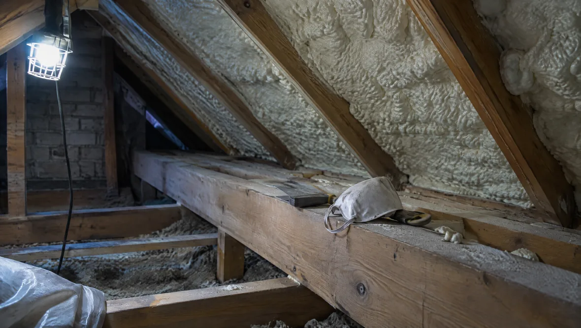 A cramped loft with a single work light and hand tools