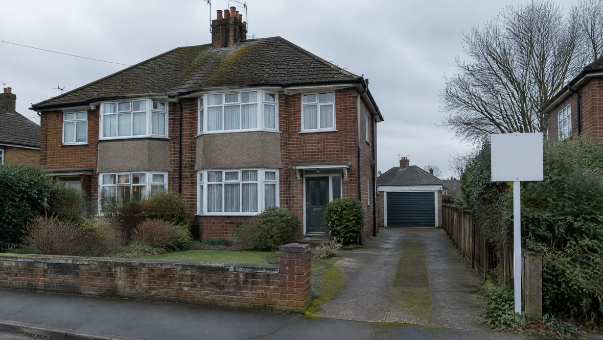 A British house exterior with a blank estate agent board outside